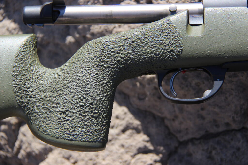 The pistol grip, trigger and bolt of a rifle