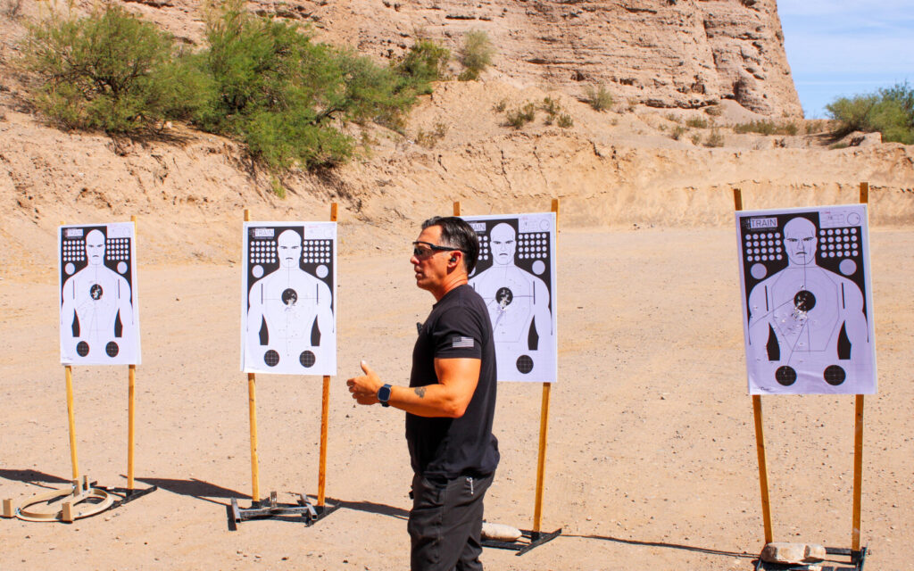 Man in front of targets on a desert background.
