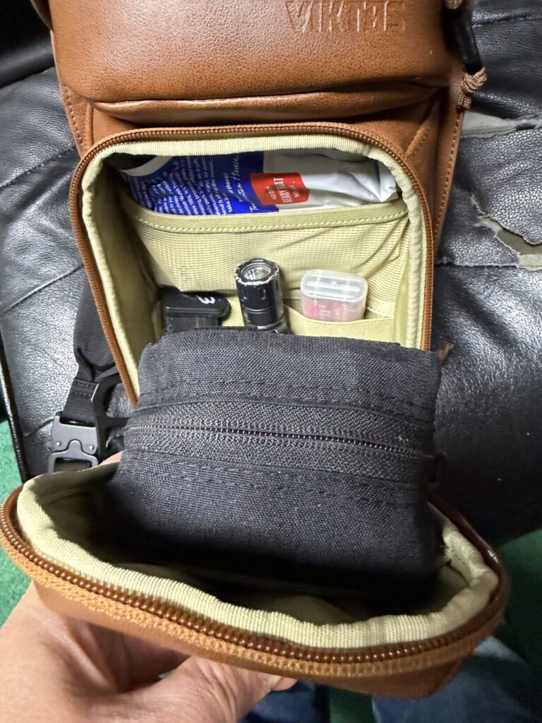 full ifak, spare pistol mag, spare flashlight/batteries, and a snack bar in viktos upscale leather sling bag