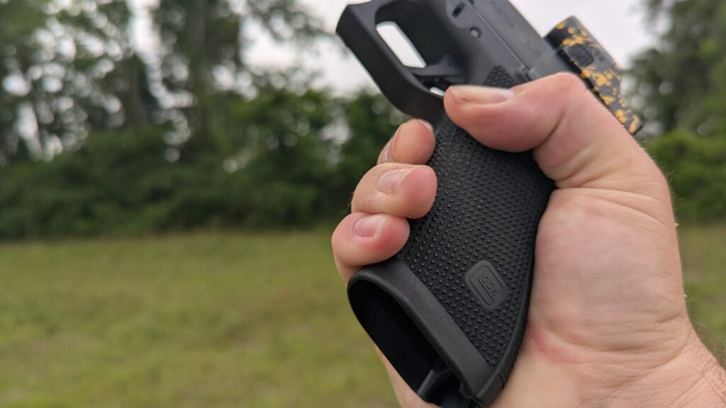Detail shot of a hand gripping a black Glock pistol