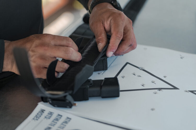 Man working on a black tactical belt.