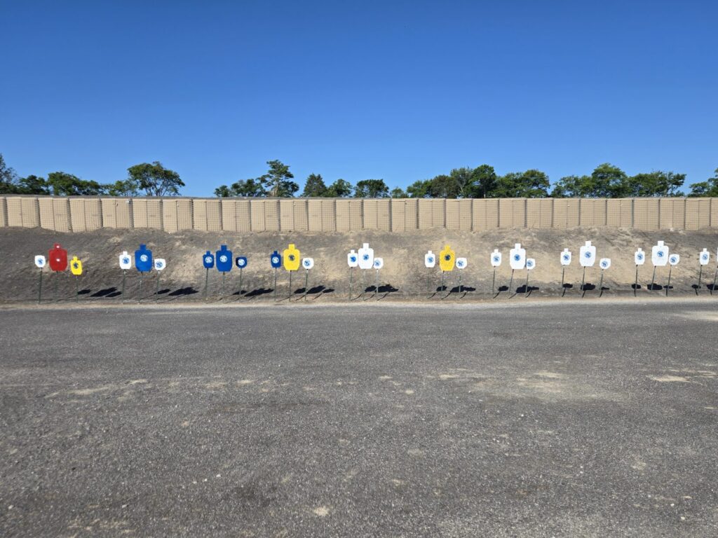 A steel range against a dirt berm with a blue sky in the background