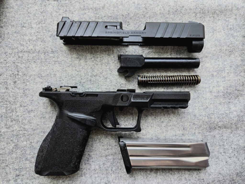A pistol field-stripped on a gray background.