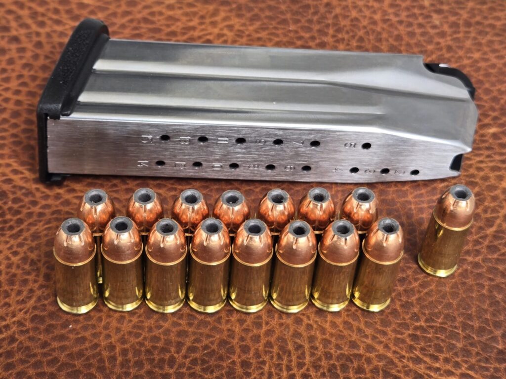 A pistol magazine and ammunition on top of a leather backdrop