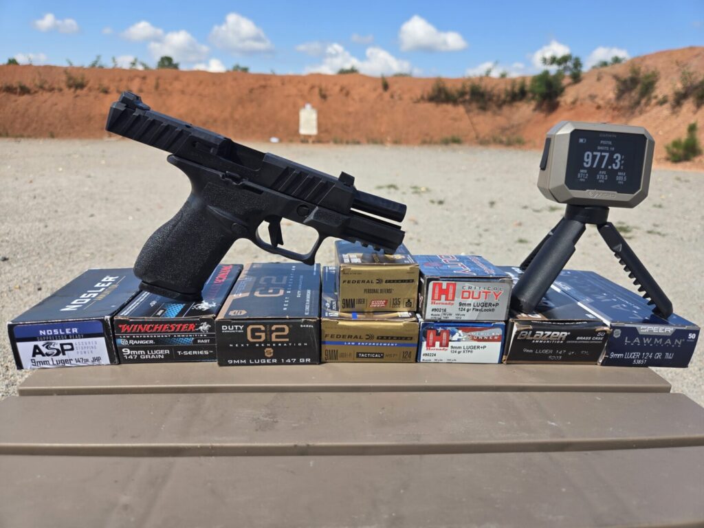 pistol ammunition on a table with springfield echelon alpha and chronograph in the foreground and a target in the background