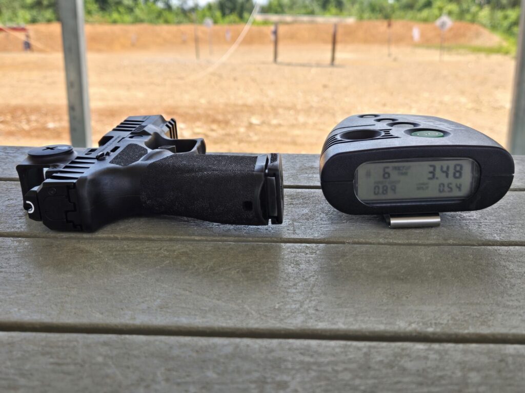 A pistol with a shot timer on a range