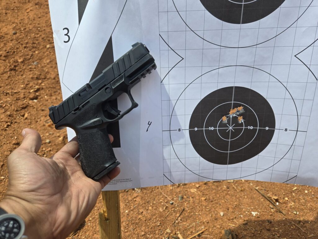springfield echelon alpha next to a target with holes in it.