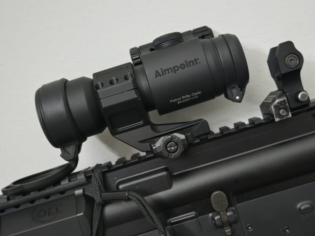A red dot optic on a cantilever mount with a back up iron sight on an AR upper