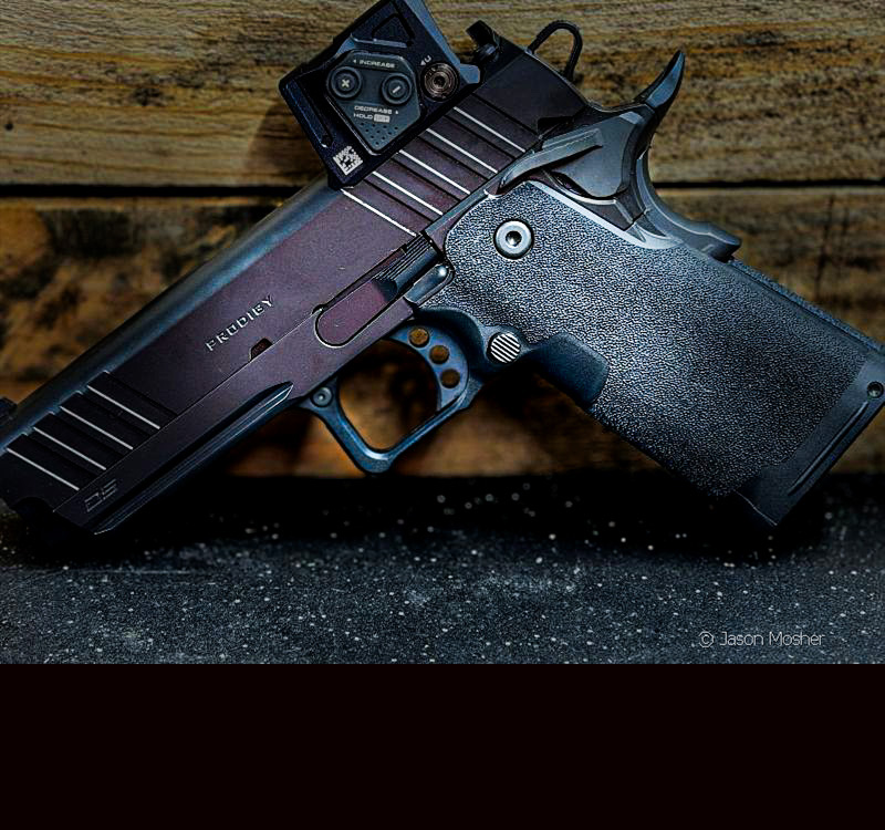 The Prodigy handgun with Aimpoint optic leaning against a wood wall. 