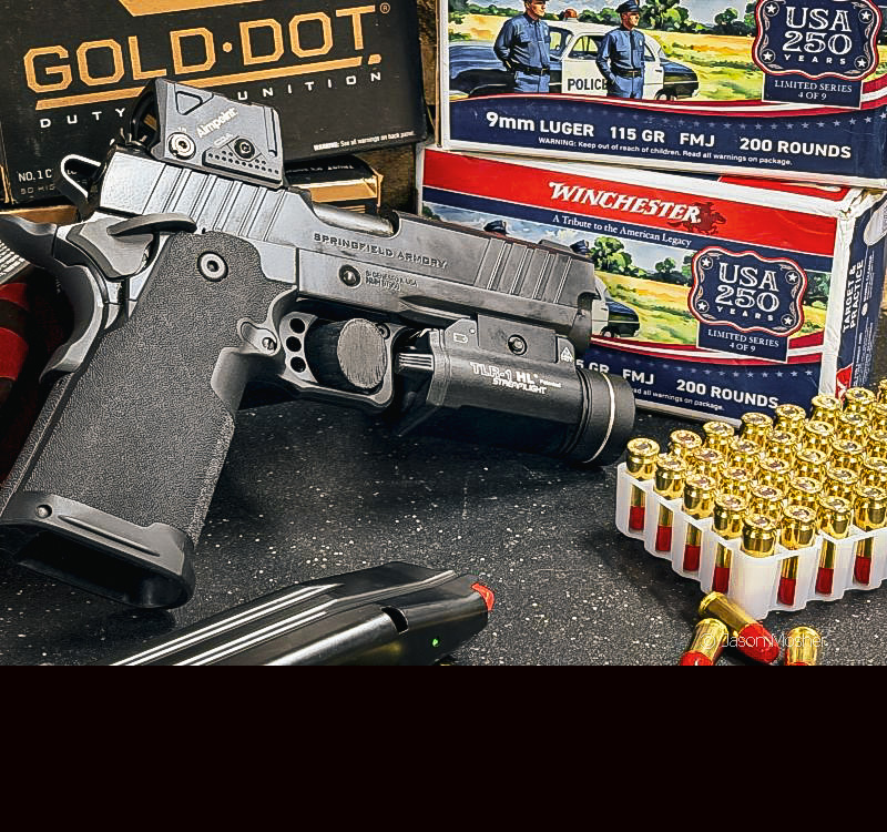 The Prodigy pistol standing up, surrounding by stacks of ammo boxes.