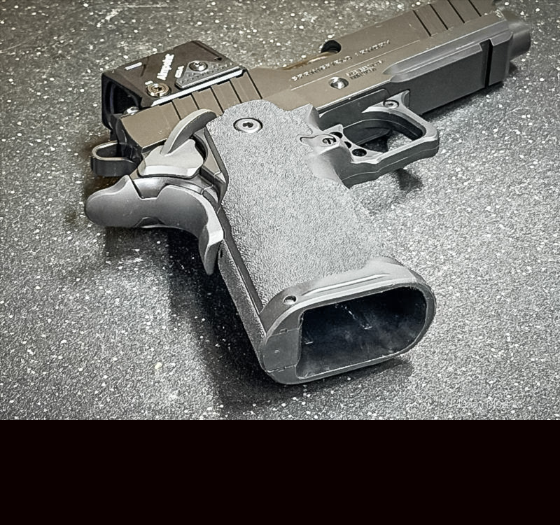 A Prodigy 1911 laying on a black surface so you can see the lightly textured grip.