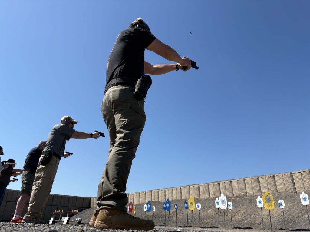Shooters on the firing line with steel targets in the background.