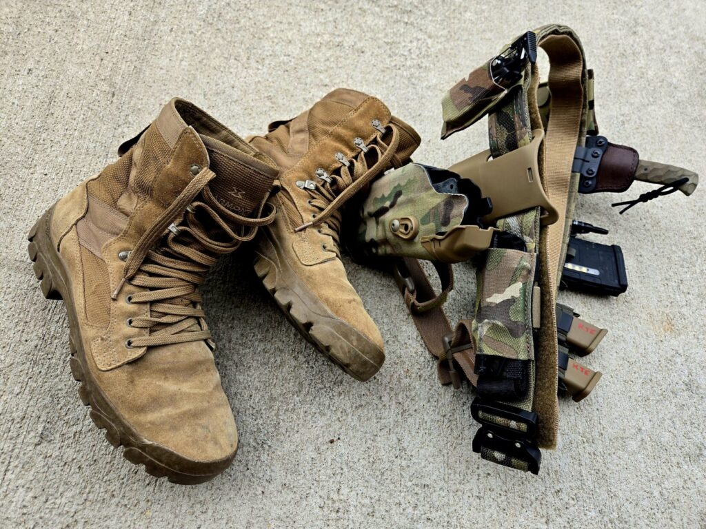 A pair of jungle boots next to a dedicated pistol belt in multicam.