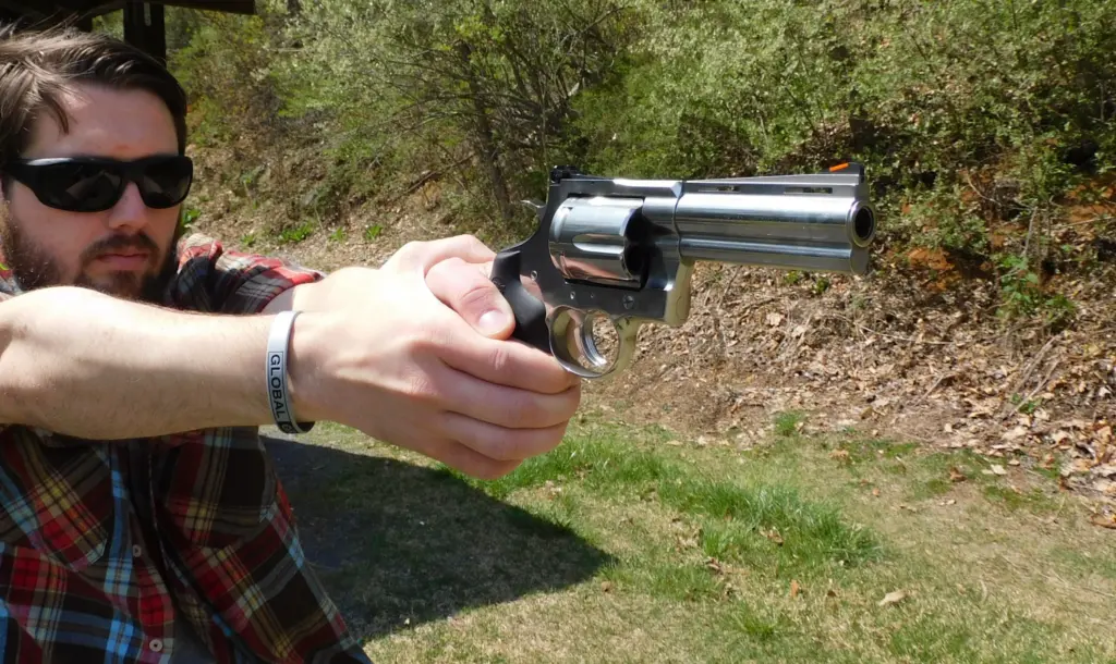 Man firing a stainless-steel revolver