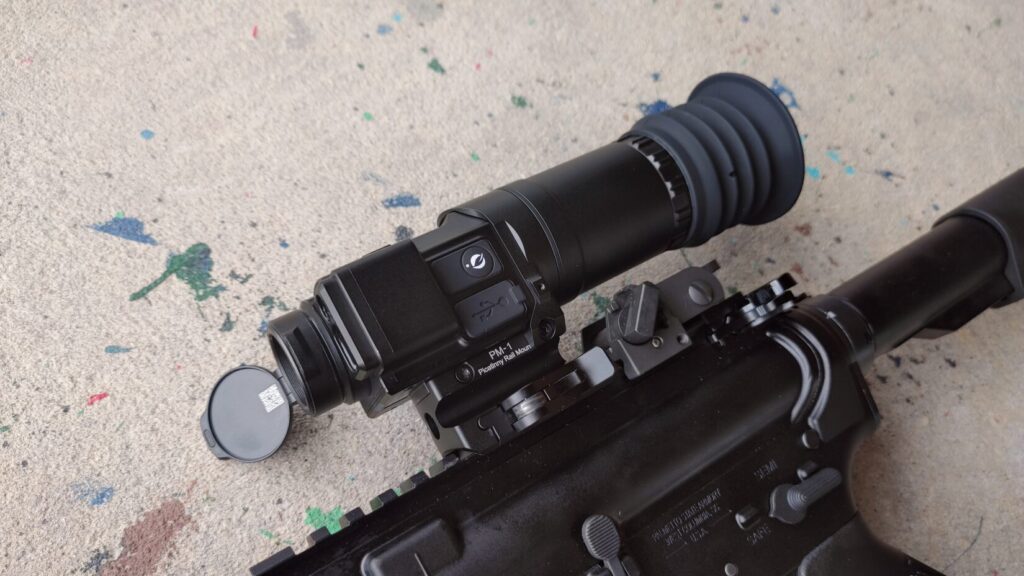 Detailed close-up view of the Mars Mini thermal unit mounted on a rifle receiver, showing the "Mars mini" text branding, dial controls, and flipped-up lens cover.
