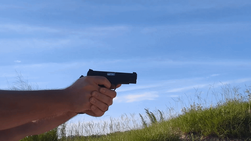 image of man moving handgun to the right and firing