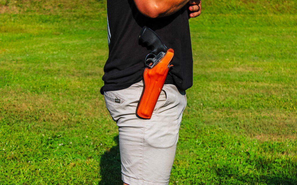Man with a leather holster outside.