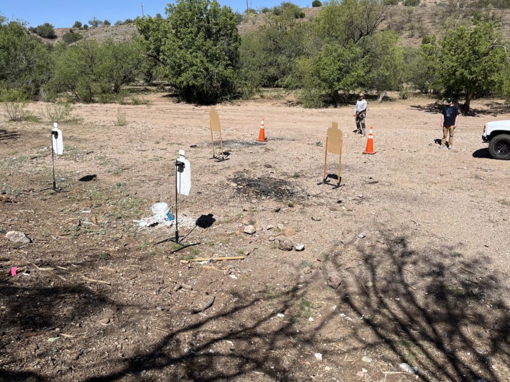 Aerial view of a target array set up for Two-Deep drills. Students stand about 15 meters from the farthest targets, which are steel. Orange traffic cones are set up 10 meters from the steel. The cones remind students not to get too close while closing with the assailant to get a clear line-of-fire.