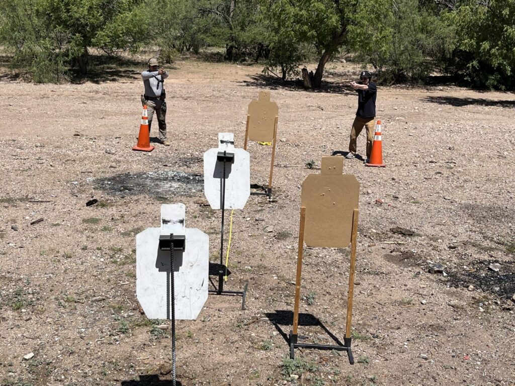 Two shooters who started together have moved apart till they have a nearby target in the apex of a capital letter L between them. In this way they avoid line of fire problems with the cluster of targets that had started out behind the threat target.
