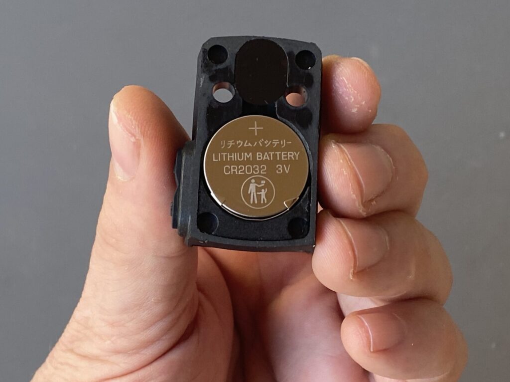 Bottom-loading CR2032 battery tray on Mantis Pink Rhino Red Dot Sight