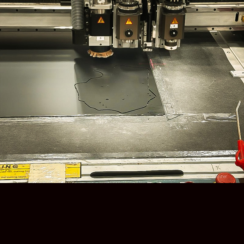 A flat sheet of Boltaron polymer being laser-cut into the shape of a holster pattern