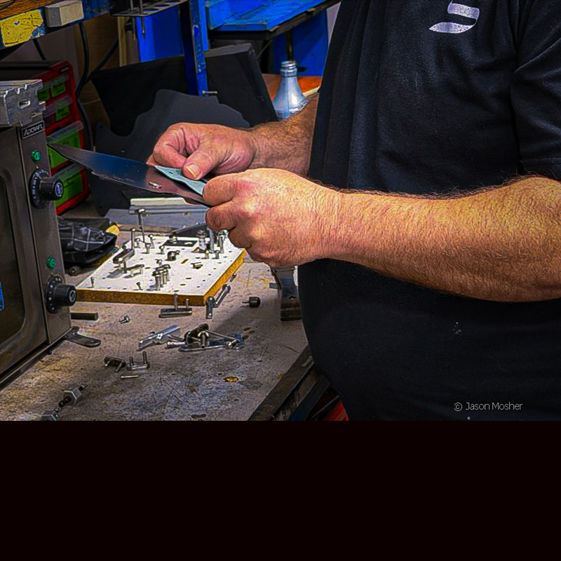 A Safariland technician hand-assembling a holster at a workbench in the Jacksonville facility