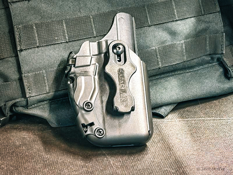 A black Safariland 575 Pro-Fit GLS IWB holster leaning up against a black bag for display.