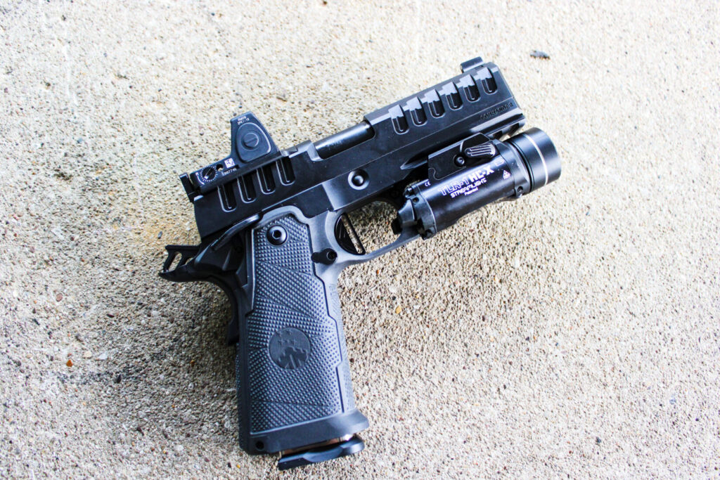 The WatchTower Apache Commander on a concrete bench. The grip texturing and aggressive slide serrations are standout features