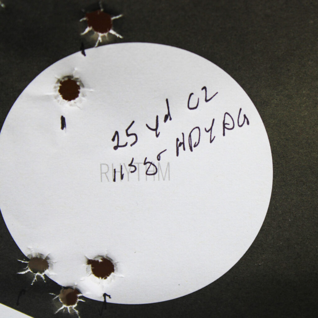 Staccato C2 25-yard accuracy test target showing a three-shot cluster low and a two-shot cluster high in the circle