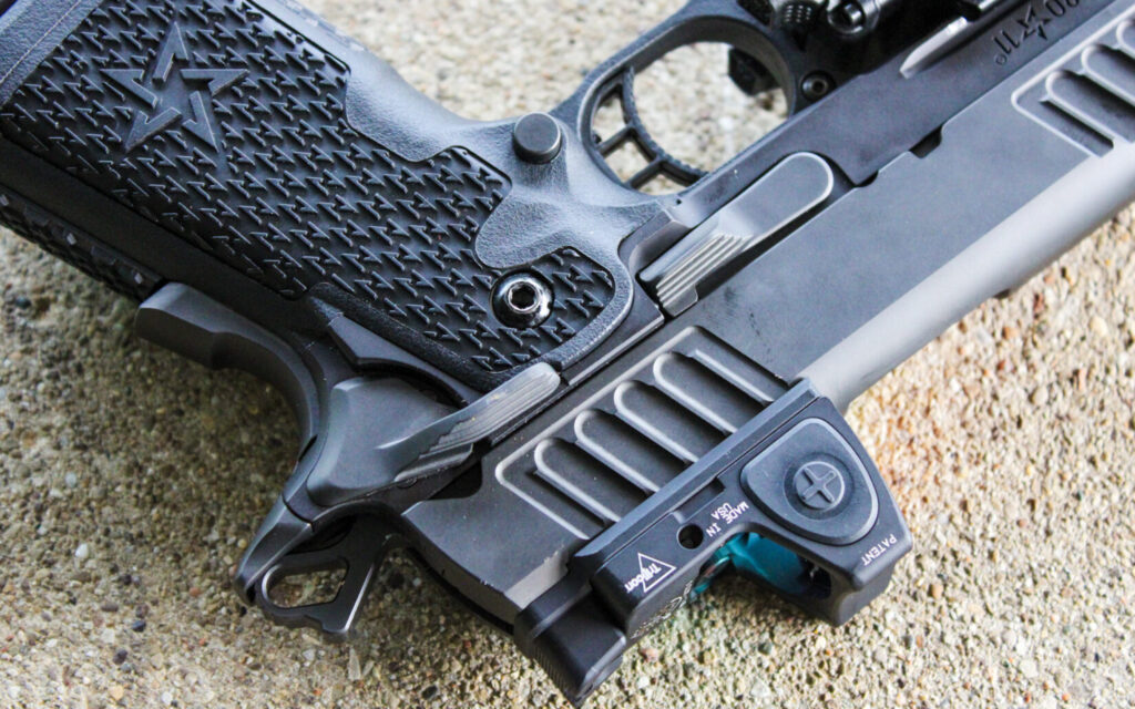 Side view of the Staccato C2 on a concrete bench showing its 1911-style safety, slide release, and magazine release