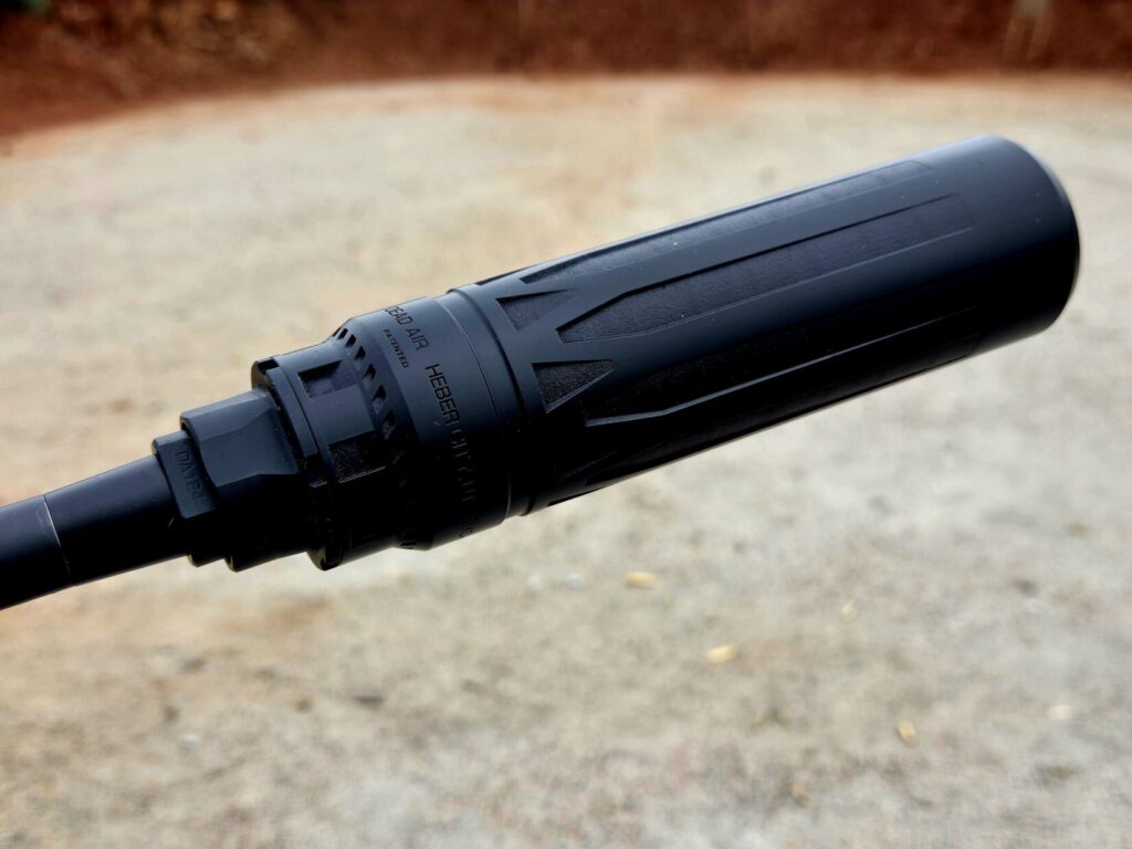 A rifle muzzle equipped with a thread adapter and suppressor.