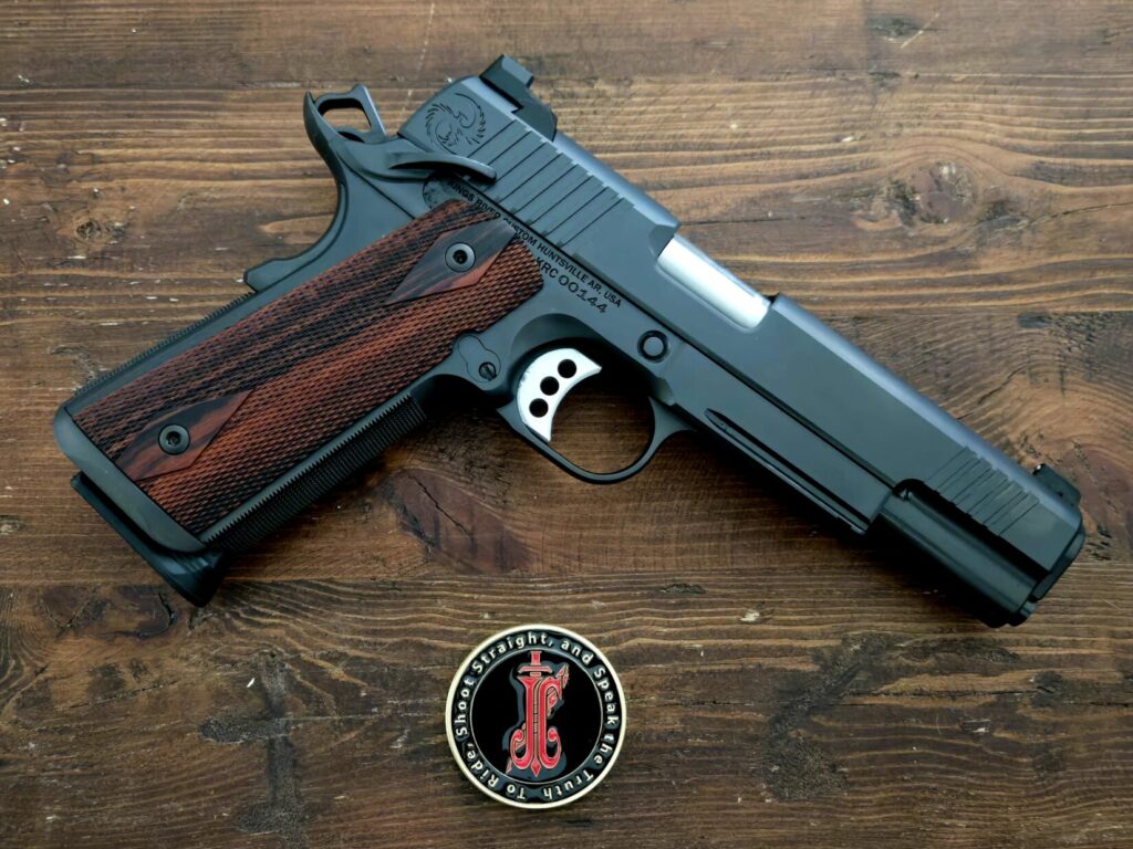A 1911 pistol with a Jeff Cooper Legacy Foundation challenge coin.