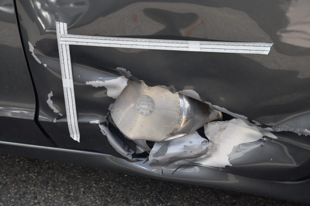 The bottom of a pressure cooker having ripped through the outside of a car door. This image was an exhibit at the trial of the second Boston Marathon bomber.