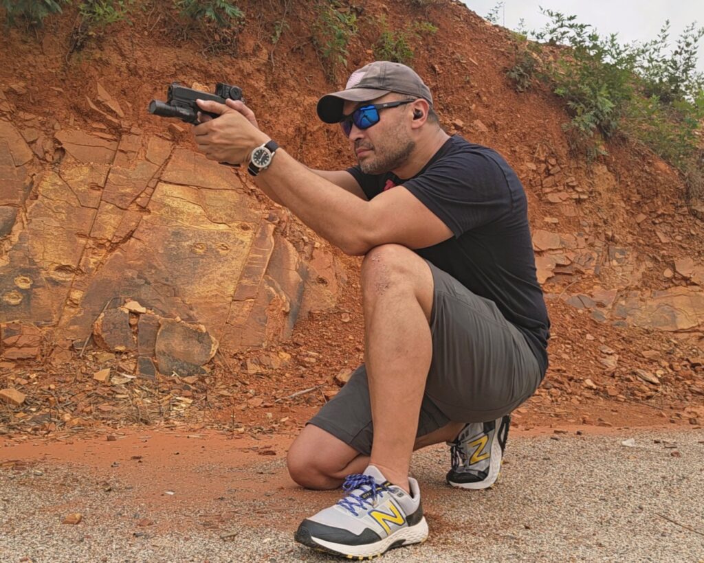 Kevin Estela shooting a Glock 45 from a kneeling position with the back of his tricep resting on his kneecap