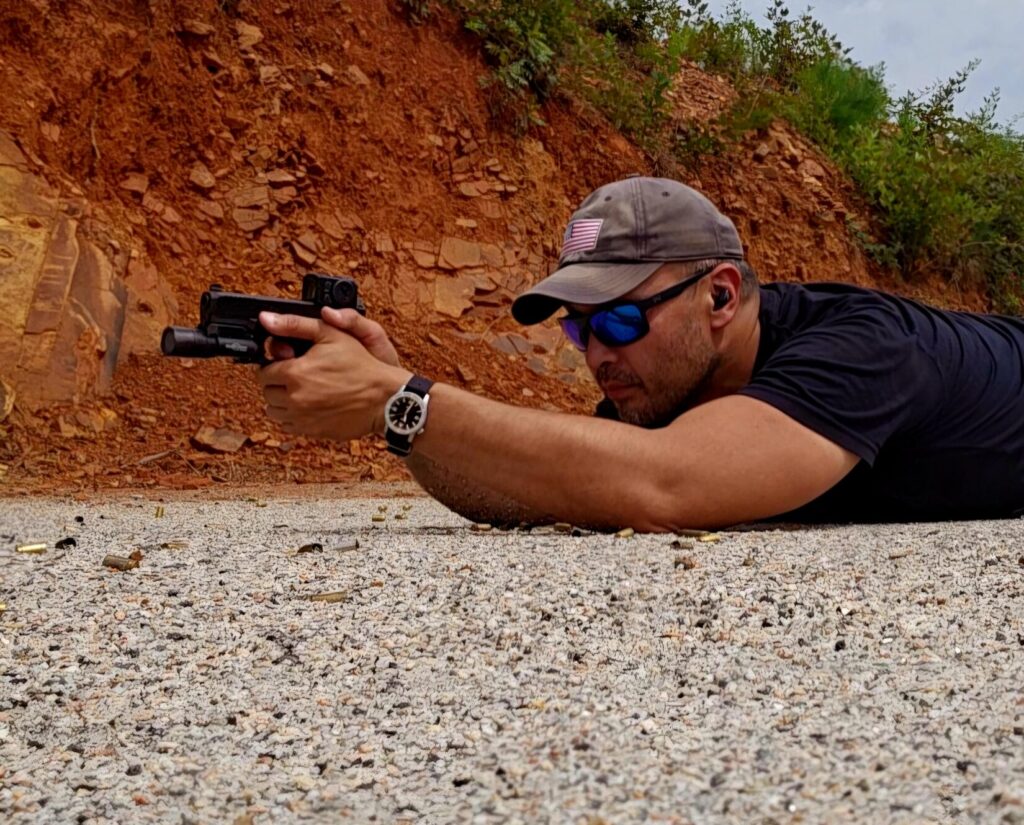 Kevin Estela shooting a Glock 45 with an Aimpoint ACRO red dot from the prone position