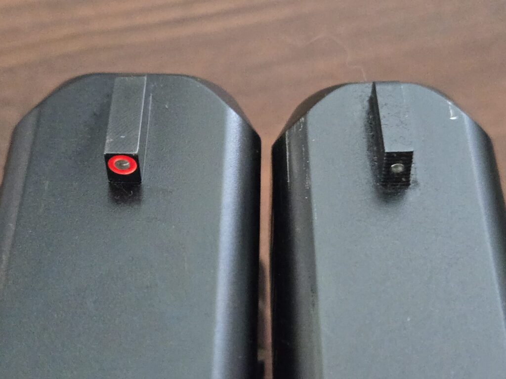 Side-by-side comparison of a wide orange-dot pistol front sight and a narrow front sight blade