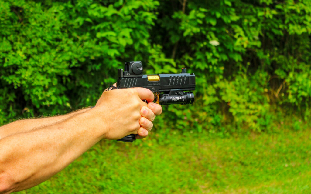 Man shooting a black gun.
