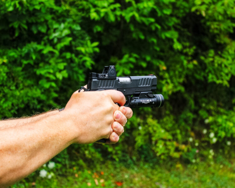 Shooting a black pistol.