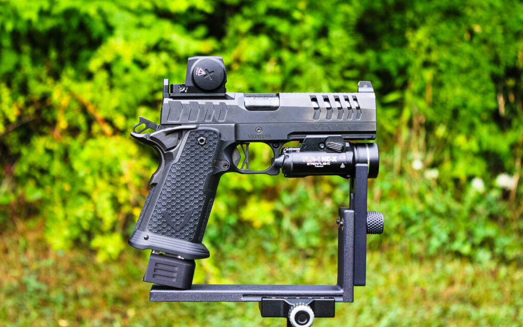 The VKTR VKP Pro double-stack 1911 in 9mm, profile view on a rest with optic and weaponlight