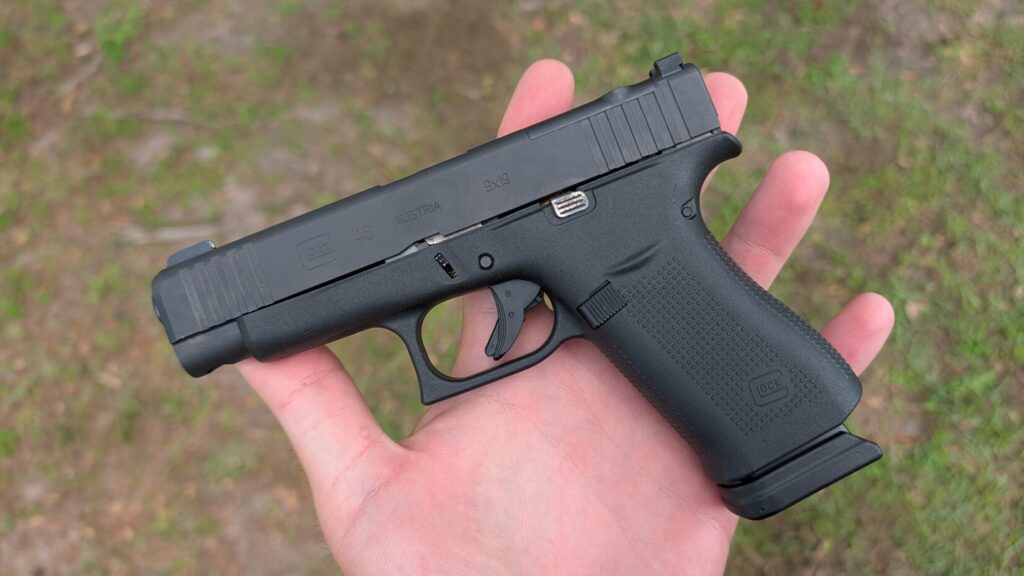 Black Glock 48 pistol resting flat in an open palm.