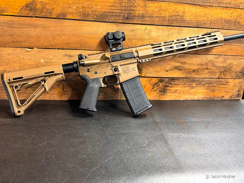 Brown Diamondback DB15 rifle leaning against a wood wall