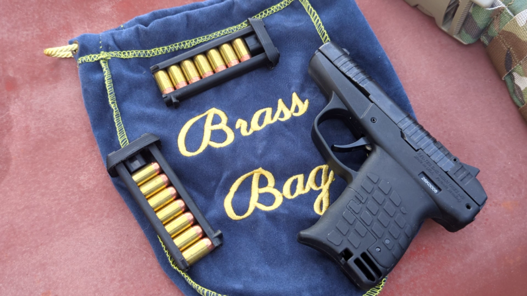 Black PR-3AT pistol and two loaded skeletonized magazines placed on a blue velvet brass collection bag.