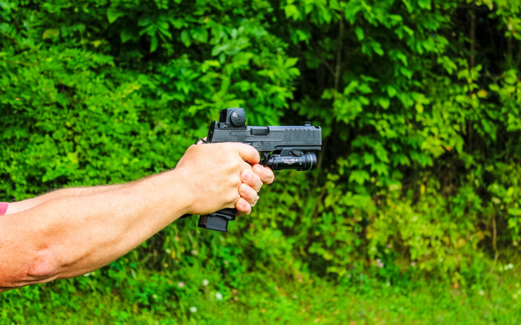 A man shooting a black pistol.