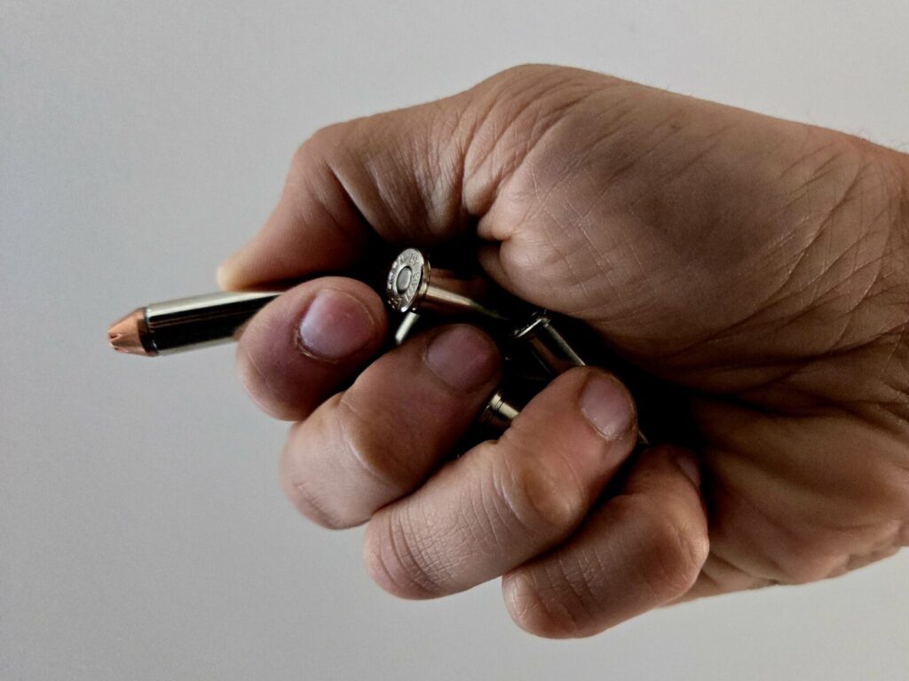 Hand holding several loose revolver cartridges for single loading