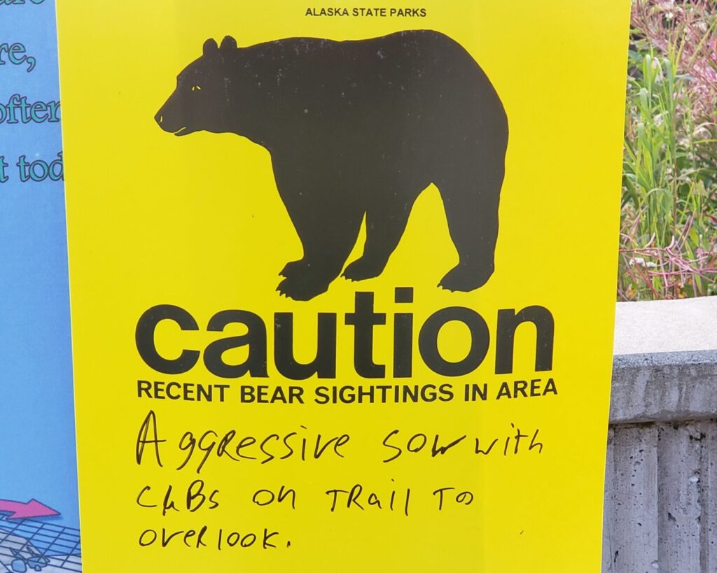 A bear warning sign with a handwritten update] Suggested alt text: "A bear warning sign with a handwritten update, posted in grizzly country