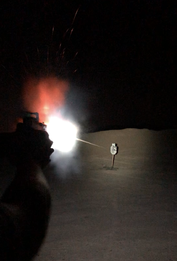 Muzzle flash from a compensator during a War HOGG Tactical low light pistol course