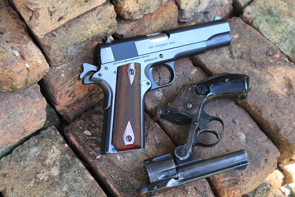 A Colt Government Model 1911 pistol and a Smith & Wesson New Departure revolver, both with grip safeties in the backstrap