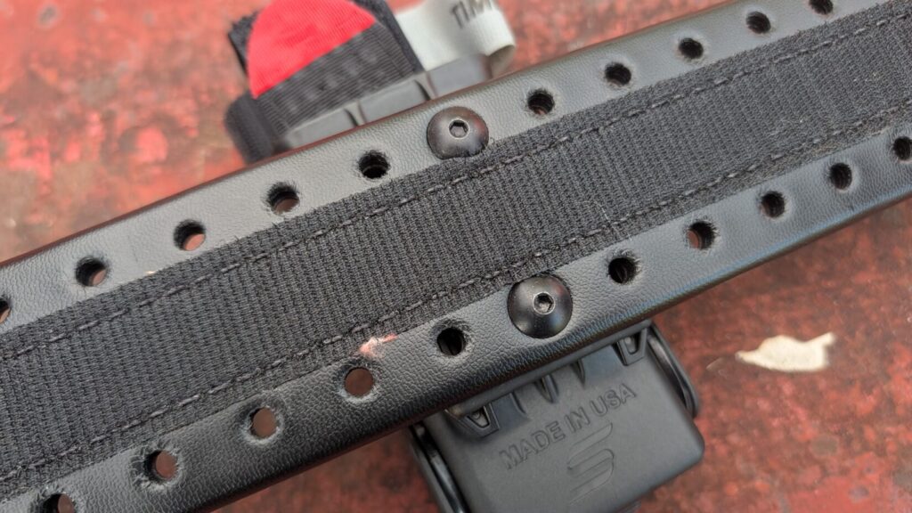 Inside of a black Safariland HOLLE belt, showing its hook-and-loop lining and flush mounting screws