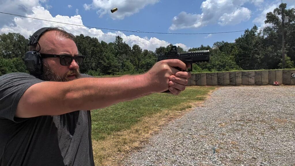 Travis Pike wearing eye and ear protection, shooting the CZ DUTY pistol at Range Ready facility