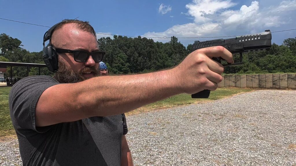 Travis Pike shooting the CZ Duty one-handed at the range ready studios range facility.